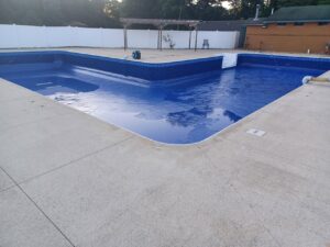 Image of a newly installed pool liner in Woodhaven, MI, showcasing a clean and modern look, completed by Downriver Pool Service after replacing the old, damaged liner