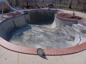 Image of an older, worn-out pool in Livonia, MI, in need of resurfacing, taken by Downriver Pool Service before completing the project